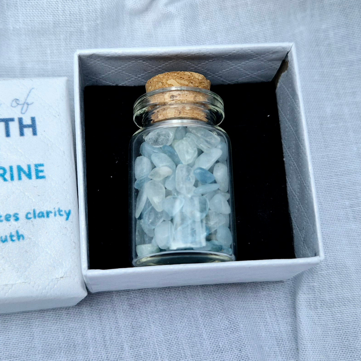 Glass jar filled with aquamarine chips