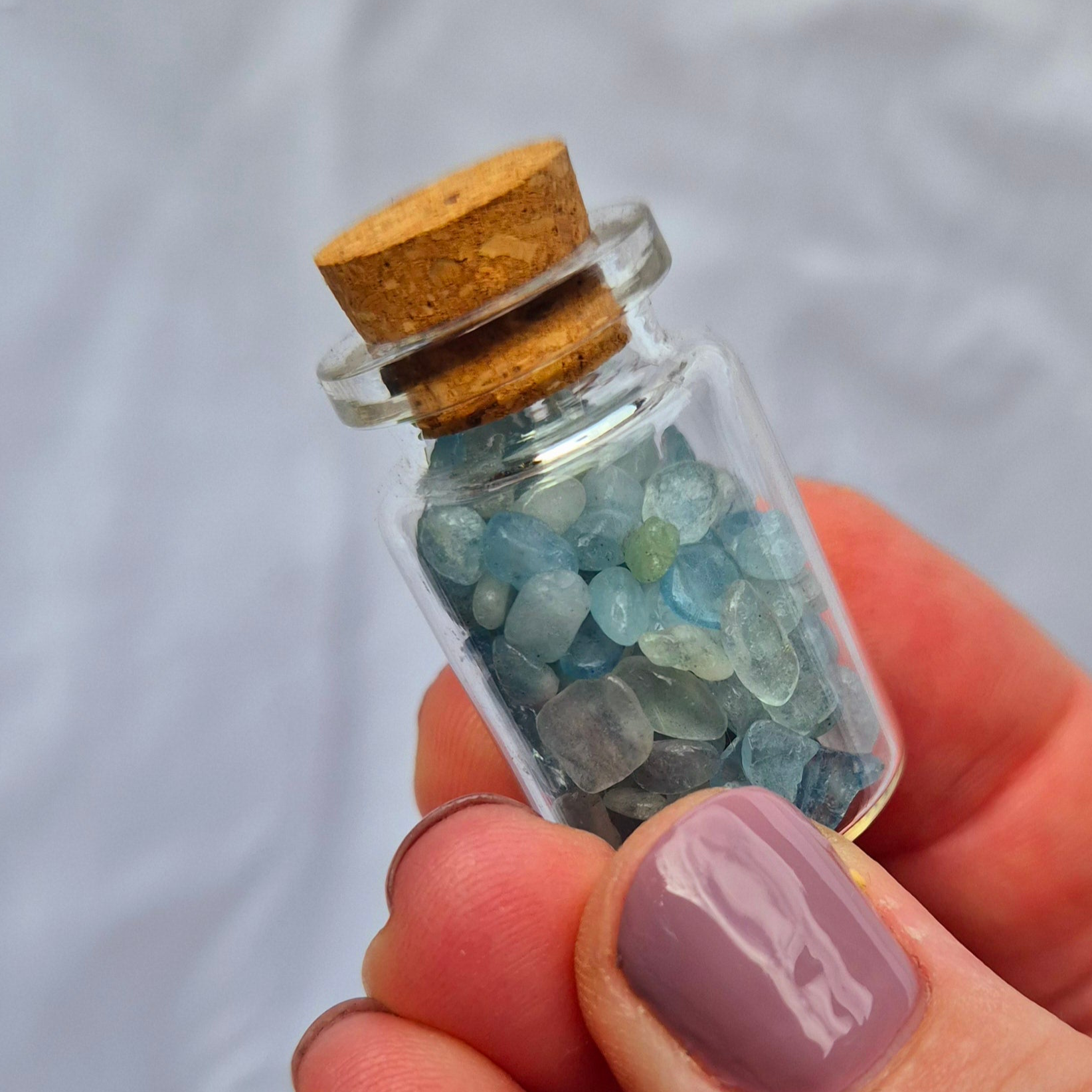 Glass jar filled with aquamarine chips