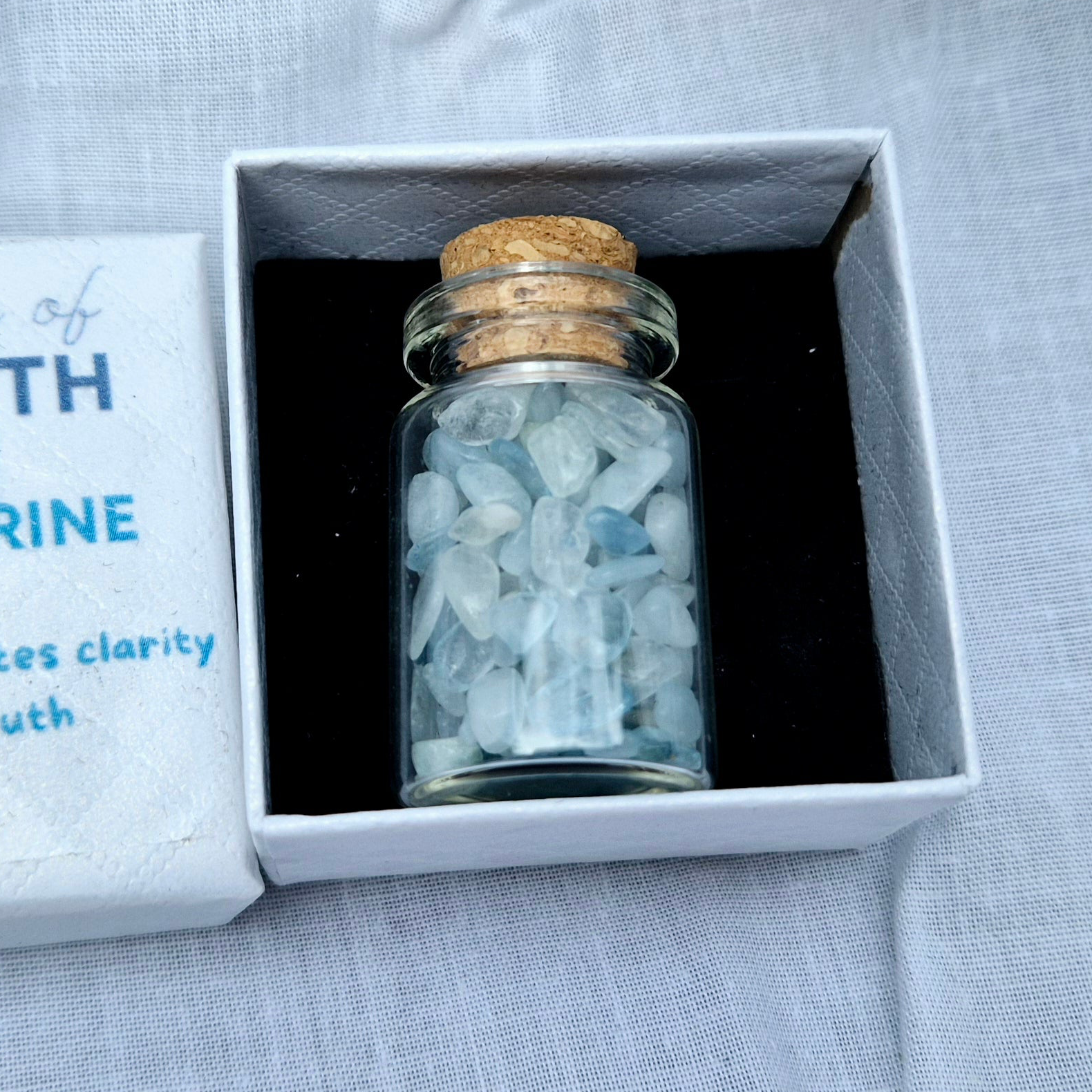 Glass jar filled with aquamarine chips
