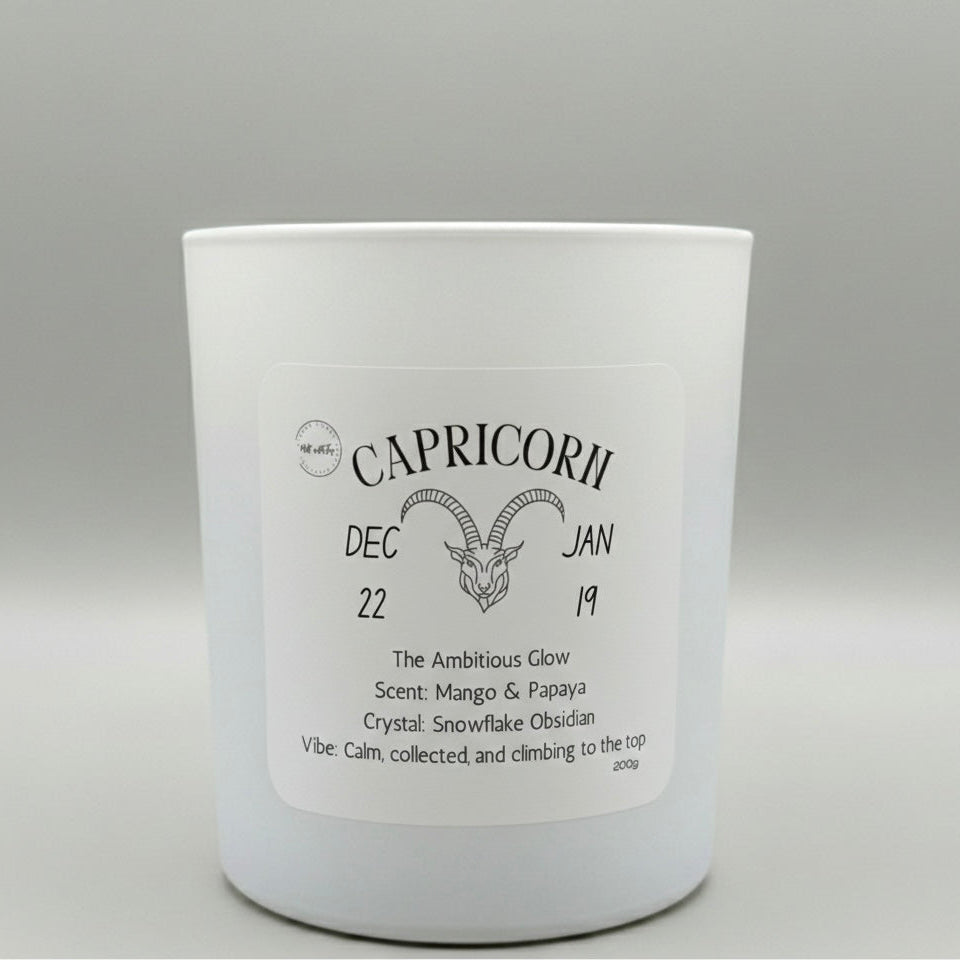 White candle with 'Capricorn' label on a gray background