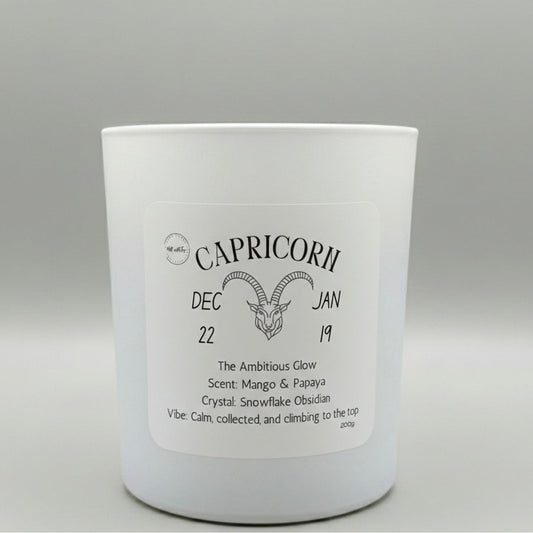 White candle with 'Capricorn' label on a gray background
