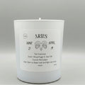 White candle with Aries zodiac information on a gray background