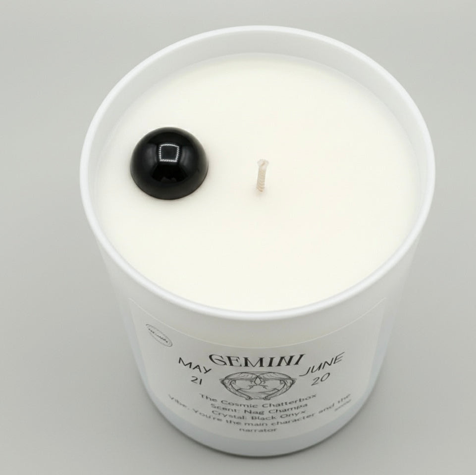 Candle in a white jar with a black lid on a gray background