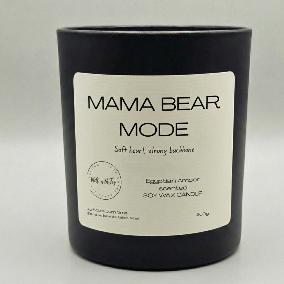 Black candle with a label titled 'Mama Bear Mode' on a light gray background