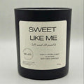 Black candle with a white label on a light gray background