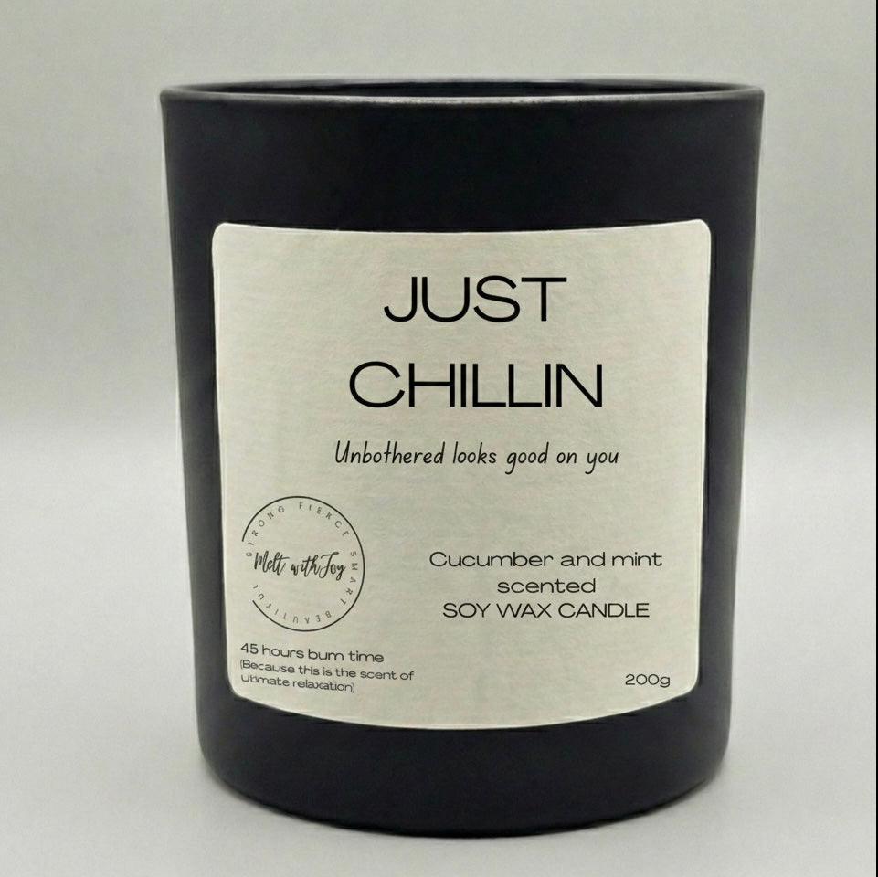 Black candle with a label reading 'Just Chillin' on a light gray background