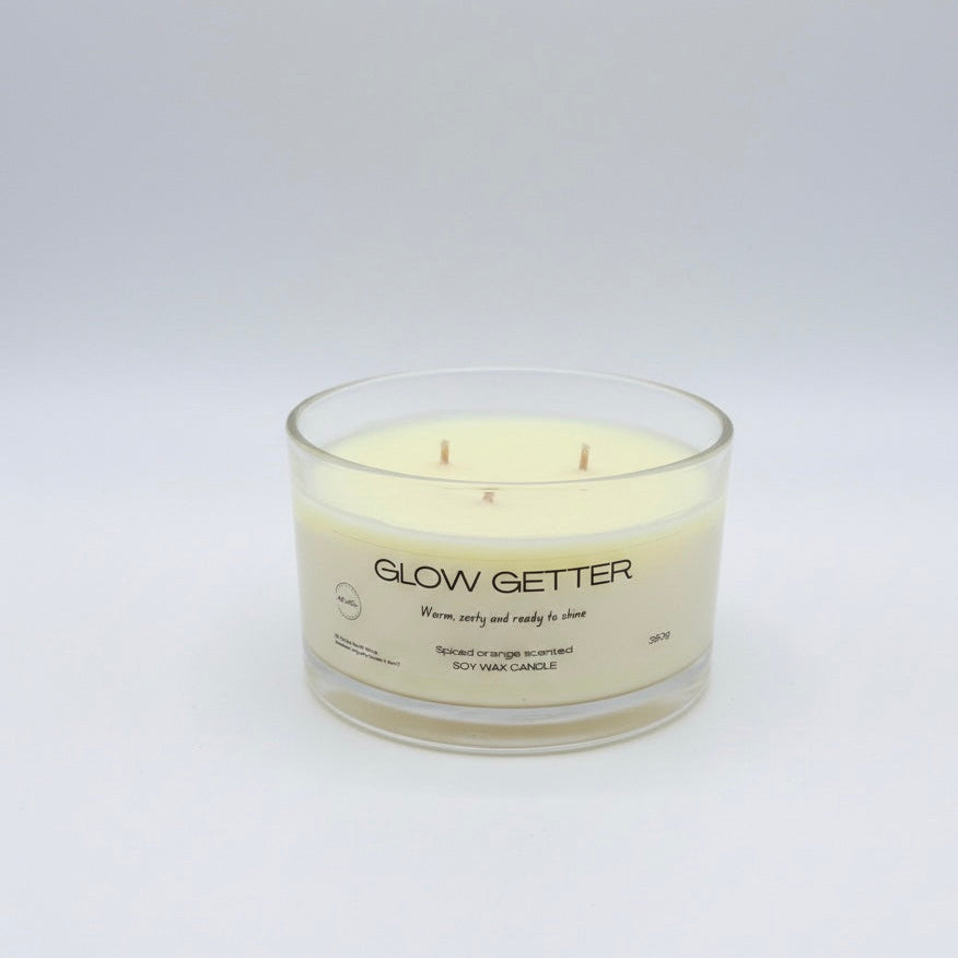Candle labeled 'Glow Getter' on a white background