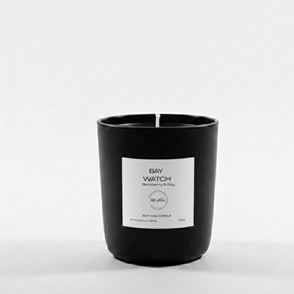 Black candle with a white label on a white background