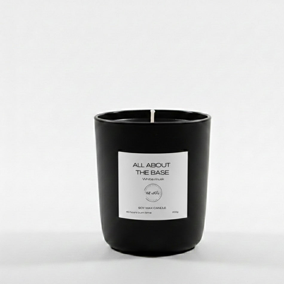Black candle with a white label on a light gray background