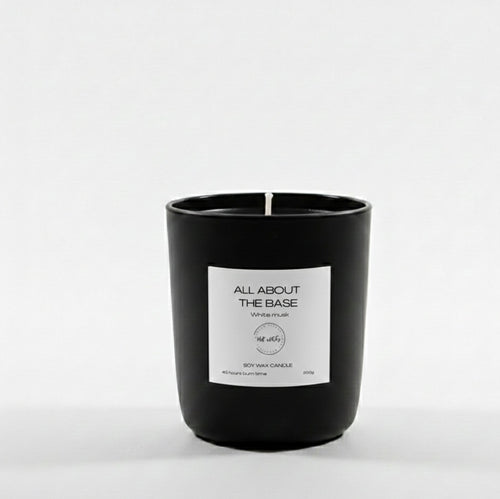 Black candle with a white label on a light gray background