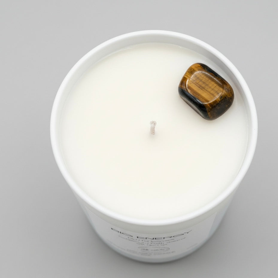Candle in a white container with a wooden lid on a gray background
